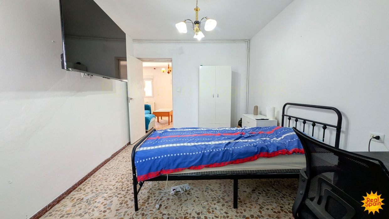 Bedroom at Cortijo Salud with blue bed cover and doorway to an adjoining room